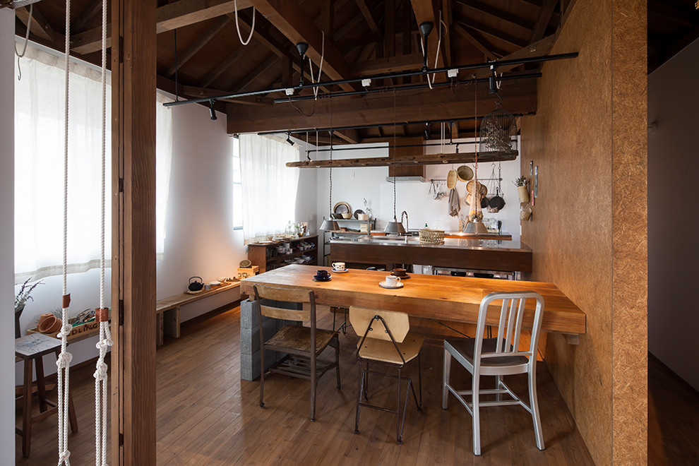 Réalisation d'une salle à manger ouverte sur le salon minimaliste avec un mur multicolore, un sol en bois brun et un sol marron.