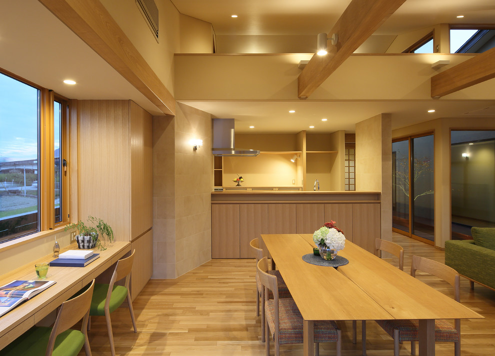 Foto di una sala da pranzo etnica con pareti beige, pavimento in legno massello medio e pavimento marrone