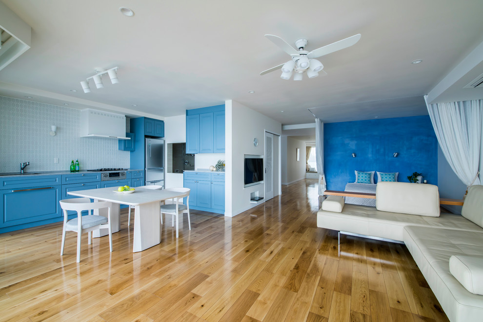 Ispirazione per una grande sala da pranzo aperta verso il soggiorno mediterranea con pareti blu, pavimento in legno massello medio e pavimento marrone