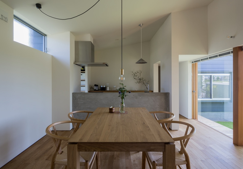 Inspiration pour une salle à manger ouverte sur le salon nordique de taille moyenne avec un mur blanc, un sol en bois brun et un sol beige.