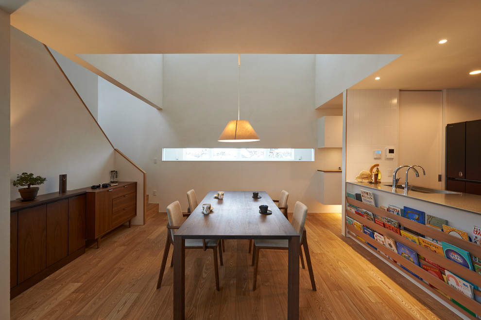 Esempio di una sala da pranzo etnica con pareti bianche, parquet chiaro e pavimento beige