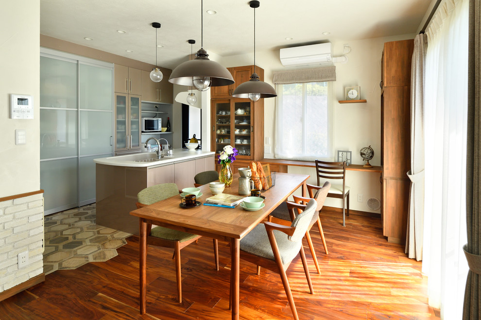 Immagine di una sala da pranzo aperta verso la cucina scandinava con pareti bianche, parquet scuro e pavimento marrone