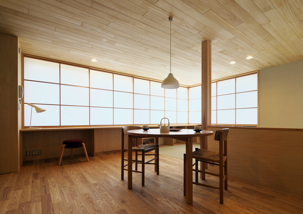 Exemple d'une salle à manger ouverte sur le salon de taille moyenne avec un mur beige, un sol en bois brun, aucune cheminée et un sol beige.