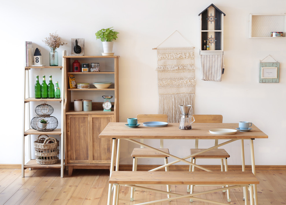 Esempio di una piccola sala da pranzo country con pareti bianche, parquet chiaro e pavimento marrone