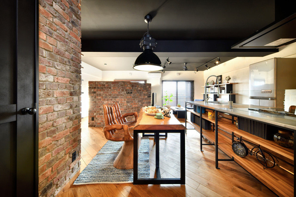 Inspiration pour une salle à manger ouverte sur le salon urbaine de taille moyenne avec un mur blanc, un sol en bois brun et un sol marron.