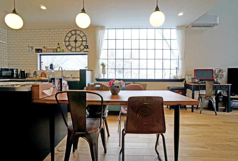 Esempio di una sala da pranzo aperta verso il soggiorno minimal con pareti bianche, pavimento in legno massello medio e pavimento marrone