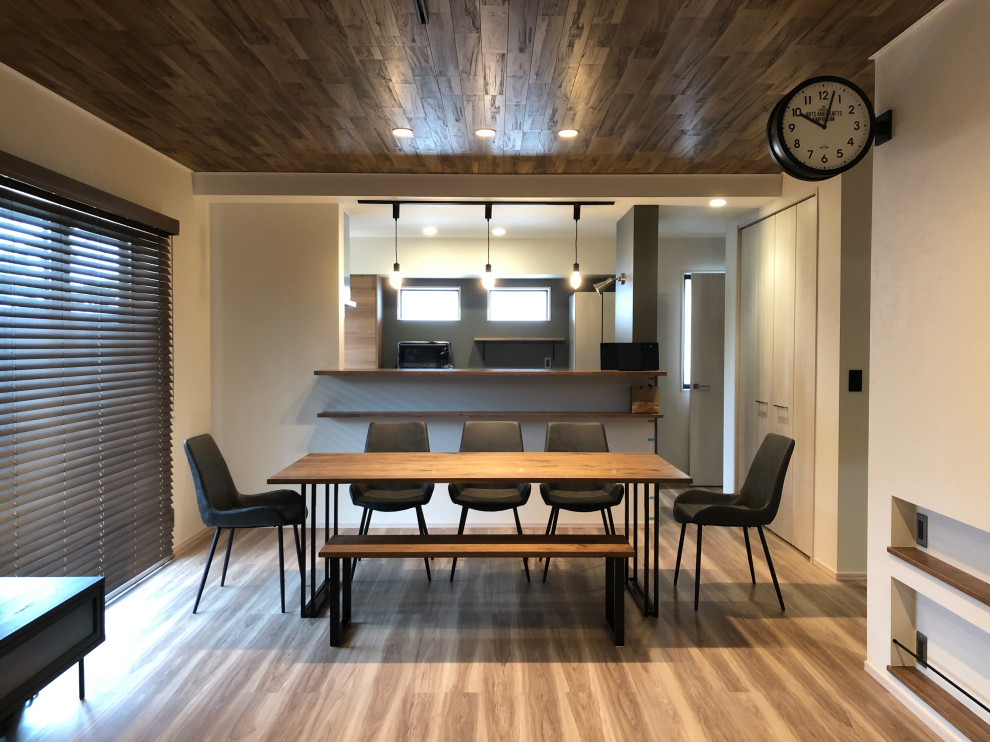 Foto di una piccola sala da pranzo aperta verso il soggiorno industriale con pareti bianche, pavimento in legno massello medio, soffitto in legno e carta da parati
