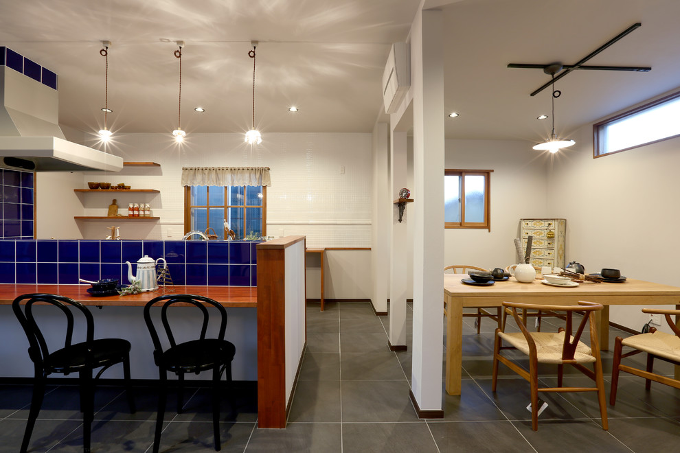 Ispirazione per una sala da pranzo aperta verso il soggiorno design con pareti bianche e pavimento grigio