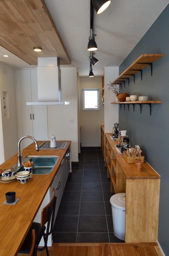 Aménagement d'une salle à manger ouverte sur le salon industrielle de taille moyenne avec un mur bleu, un sol en bois brun, aucune cheminée et un sol noir.
