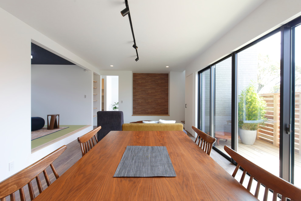 Идея дизайна: гостиная-столовая в стиле модернизм с белыми стенами, деревянным полом и серым полом
