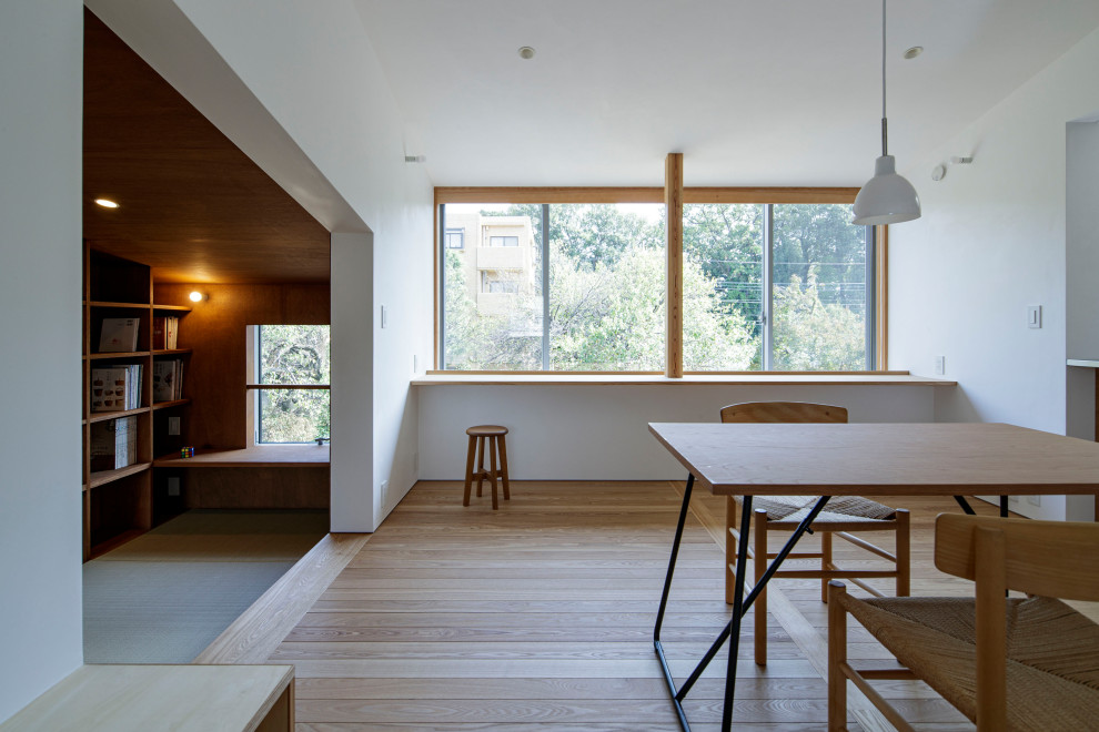 На фото: кухня-столовая среднего размера в стиле модернизм с белыми стенами, паркетным полом среднего тона и бежевым полом без камина с
