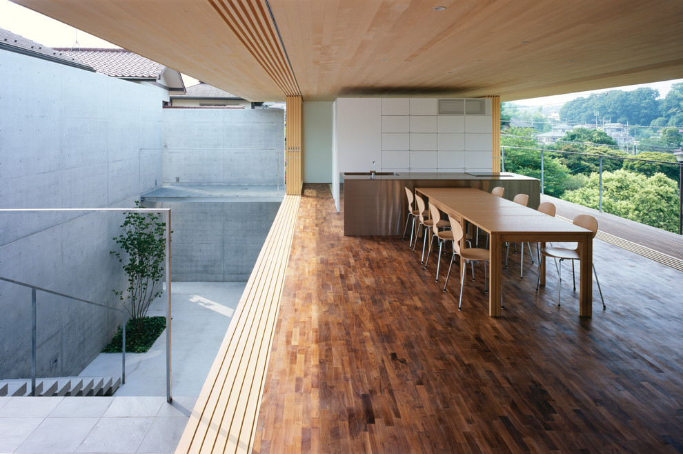 Cette photo montre une salle à manger ouverte sur la cuisine tendance avec un sol en bois brun et aucune cheminée.