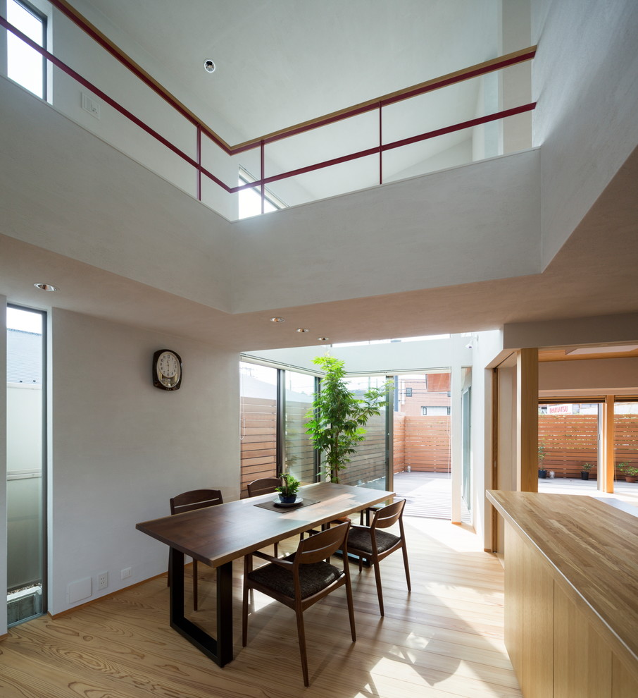 Diseño de comedor de estilo zen abierto con paredes blancas, suelo de madera en tonos medios y suelo marrón