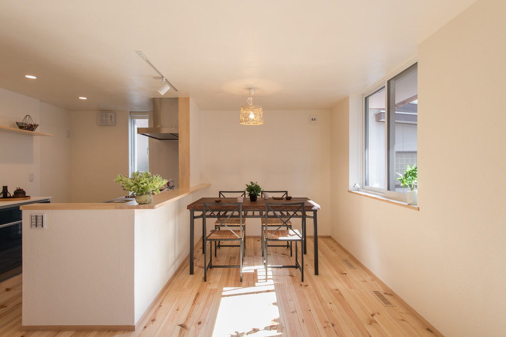 Inspiration for a light wood floor and brown floor dining room remodel in Tokyo Suburbs with white walls