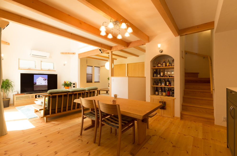 Aménagement d'une salle à manger ouverte sur le salon asiatique avec un mur blanc, un sol en bois brun et un sol marron.