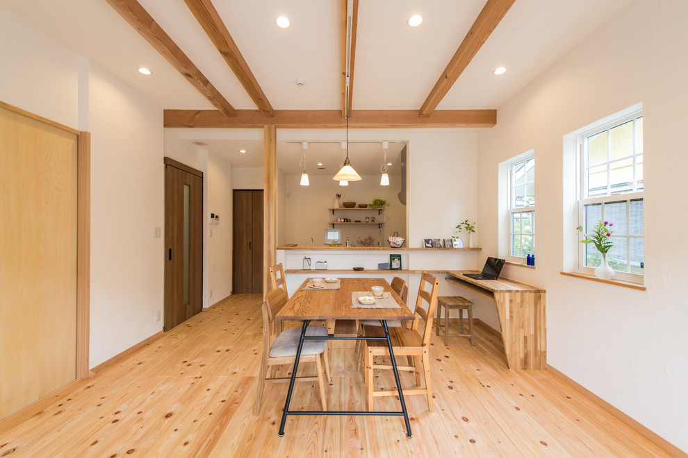 Cette photo montre une salle à manger ouverte sur le salon asiatique avec un mur blanc, un sol en bois brun et un sol marron.