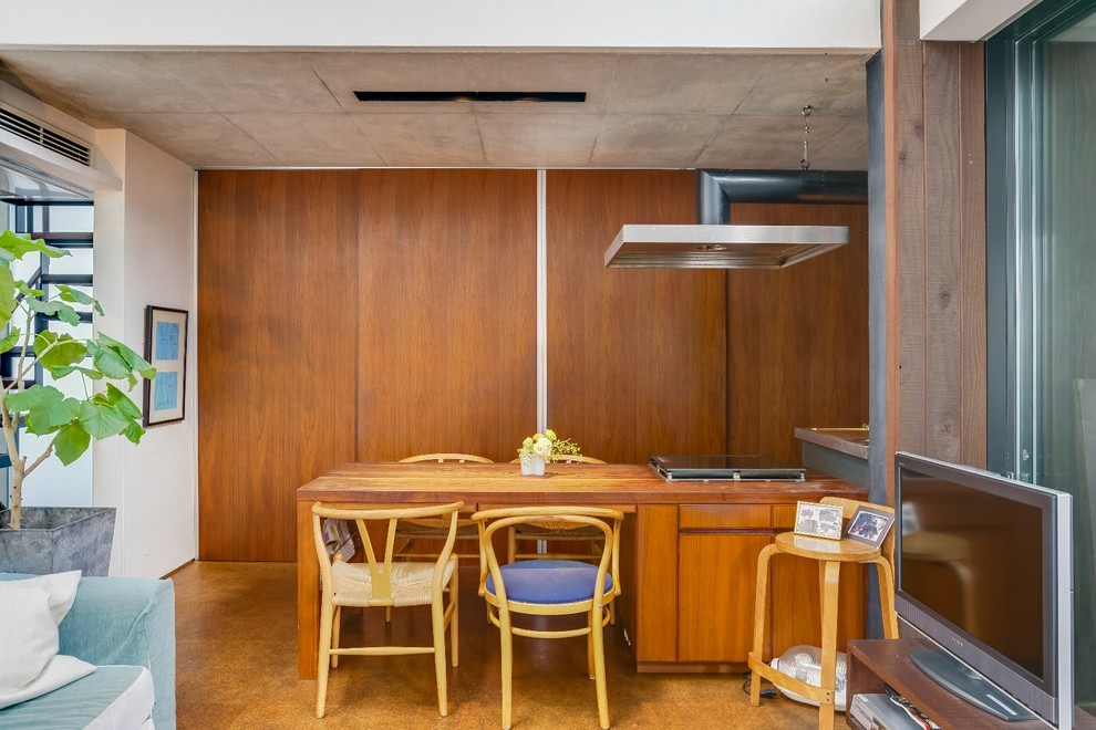 Idee per una sala da pranzo aperta verso il soggiorno minimalista di medie dimensioni con pareti marroni, pavimento in sughero, stufa a legna e pavimento beige