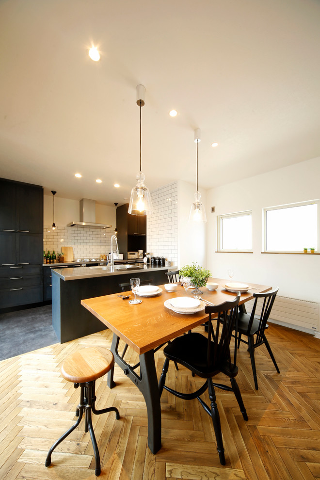 Aménagement d'une salle à manger ouverte sur la cuisine classique avec un mur blanc, un sol en bois brun et un sol marron.