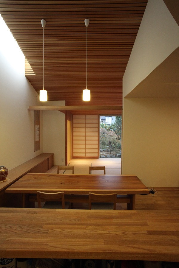 На фото: гостиная-столовая среднего размера в стиле модернизм с белыми стенами, паркетным полом среднего тона, коричневым полом и деревянным потолком без камина