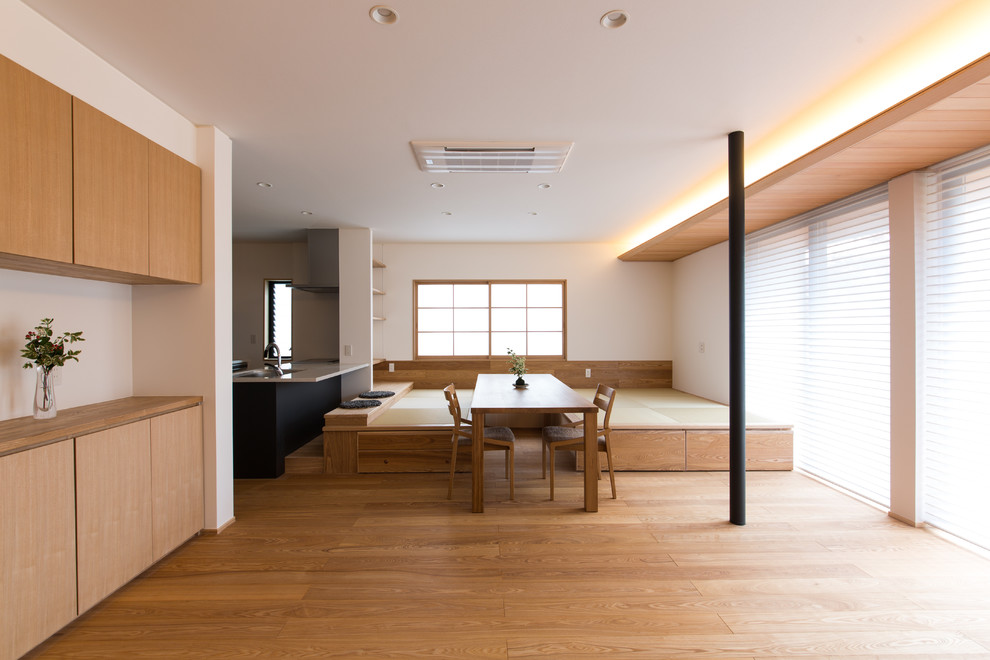 Modern inredning av en matplats med öppen planlösning, med vita väggar och tatamigolv