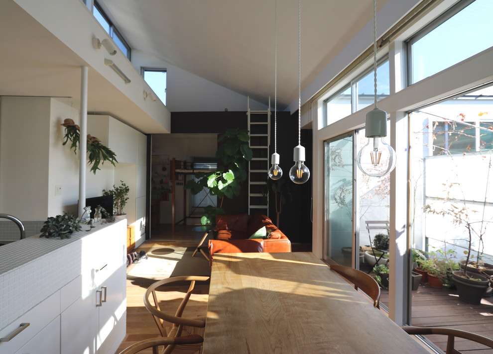 Modelo de comedor minimalista de tamaño medio abierto con paredes multicolor, suelo de madera clara y suelo beige
