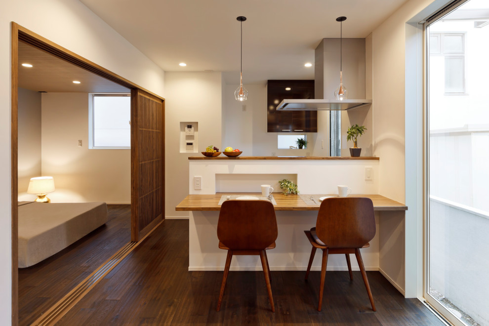 Exempel på ett modernt kök med matplats, med vita väggar, mörkt trägolv och brunt golv