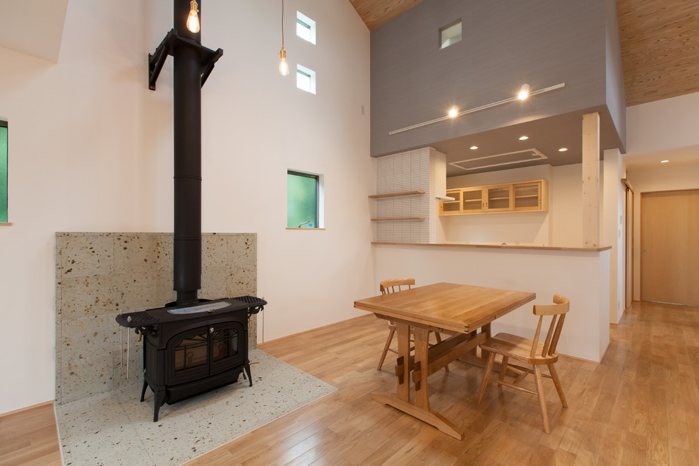 Idee per una sala da pranzo aperta verso il soggiorno minimalista con pareti bianche, pavimento in legno massello medio e pavimento marrone