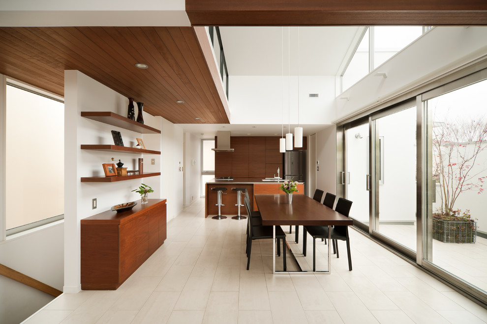 На фото: кухня-столовая в стиле модернизм с белыми стенами и полом из керамической плитки без камина с