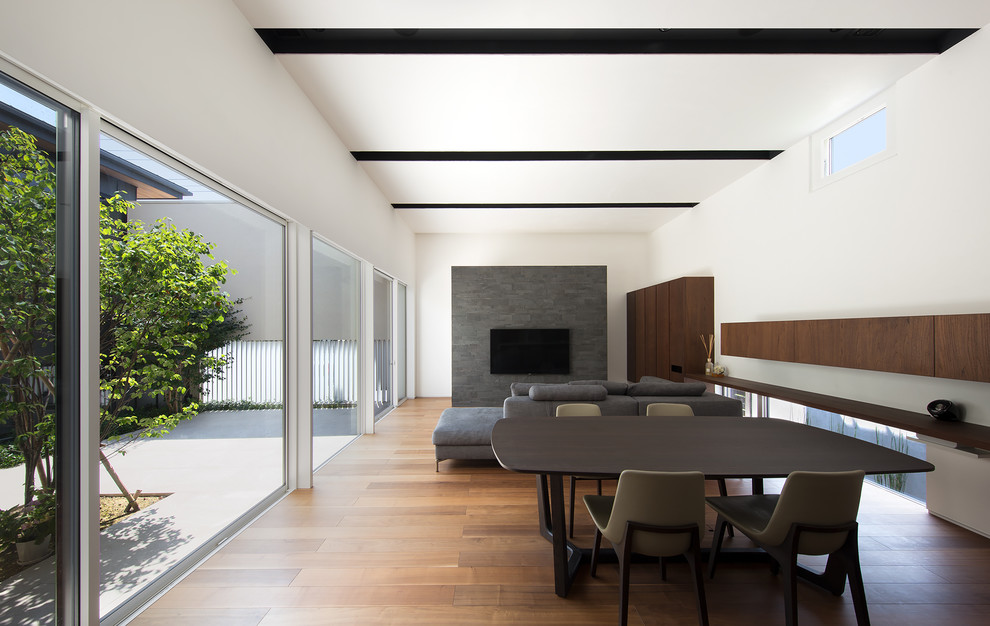 Ispirazione per una sala da pranzo minimalista con pareti bianche, pavimento in legno massello medio e pavimento marrone
