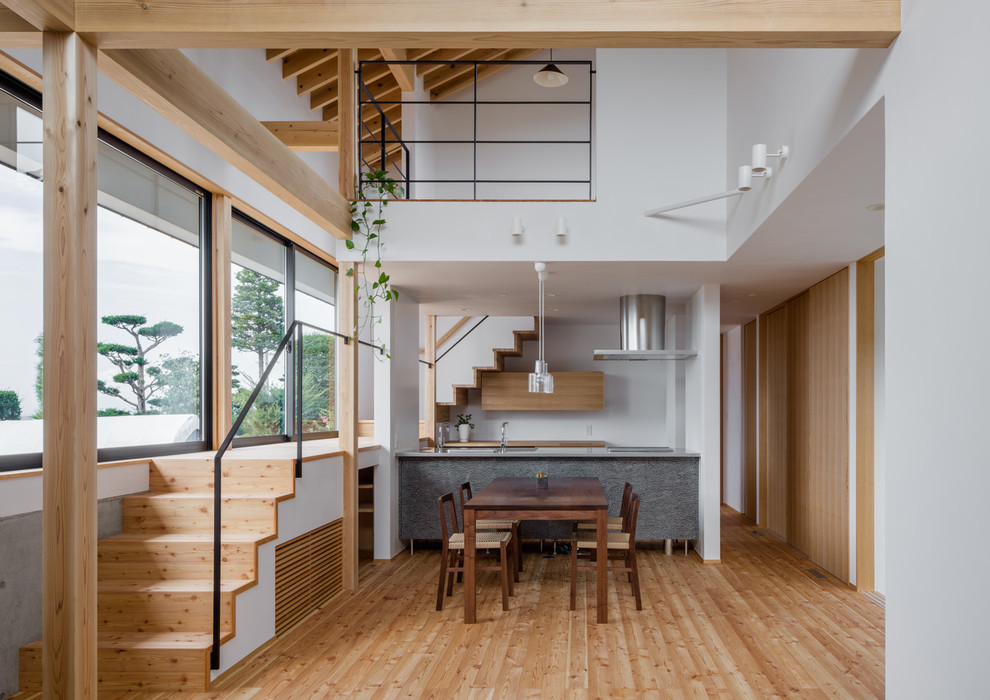 Exemple d'une salle à manger ouverte sur la cuisine scandinave de taille moyenne avec un mur blanc et parquet clair.