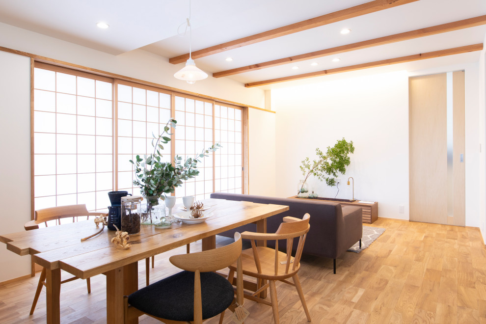 Idée de décoration pour une salle à manger ouverte sur le salon asiatique avec un mur blanc, un sol en bois brun, aucune cheminée et un plafond en papier peint.