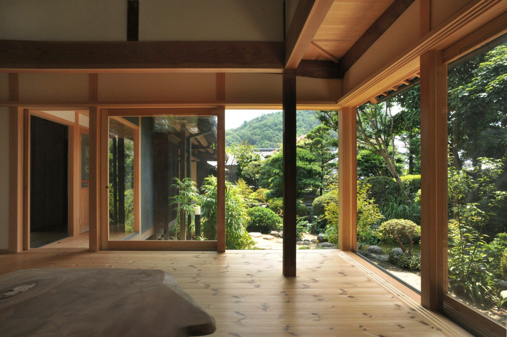 Offenes Asiatisches Esszimmer mit weißer Wandfarbe, hellem Holzboden, braunem Boden und Holzdecke in Sonstige