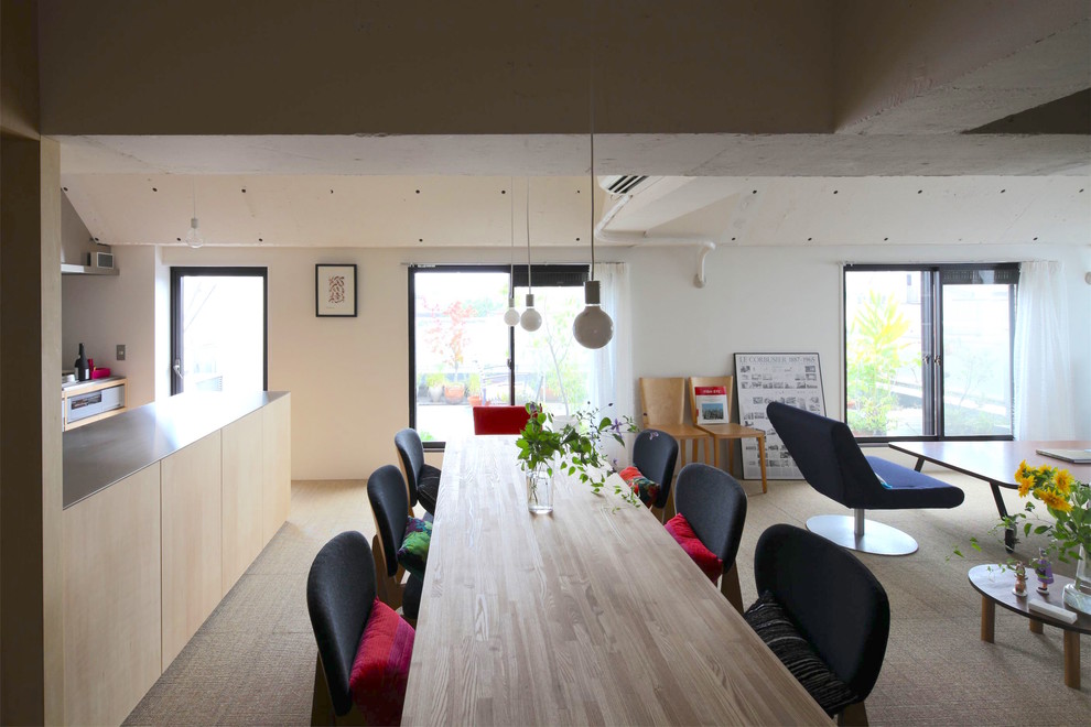 Immagine di una sala da pranzo aperta verso il soggiorno design con pareti bianche, moquette e nessun camino