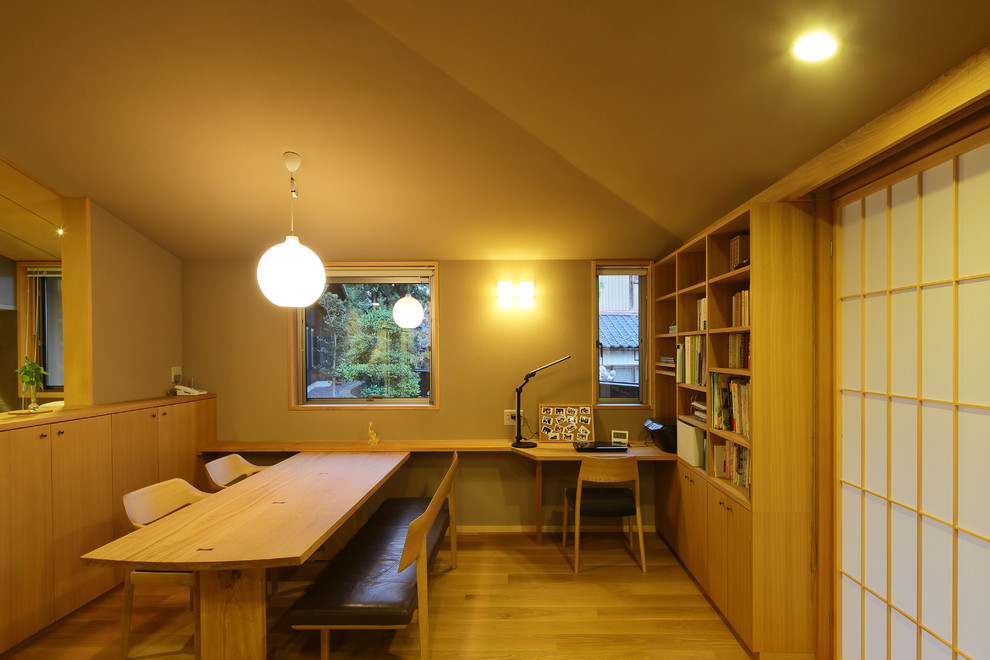Inspiration pour une salle à manger ouverte sur le salon asiatique avec un mur beige, parquet clair et éclairage.