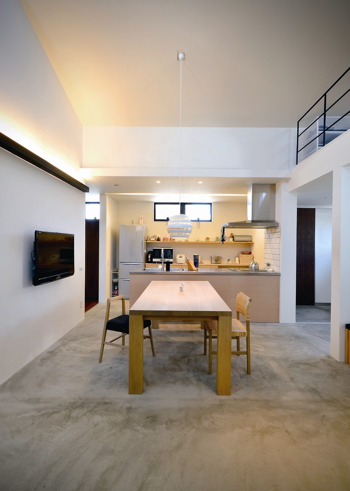 Idée de décoration pour une salle à manger ouverte sur le salon urbaine de taille moyenne avec sol en béton ciré, un sol gris et un mur blanc.