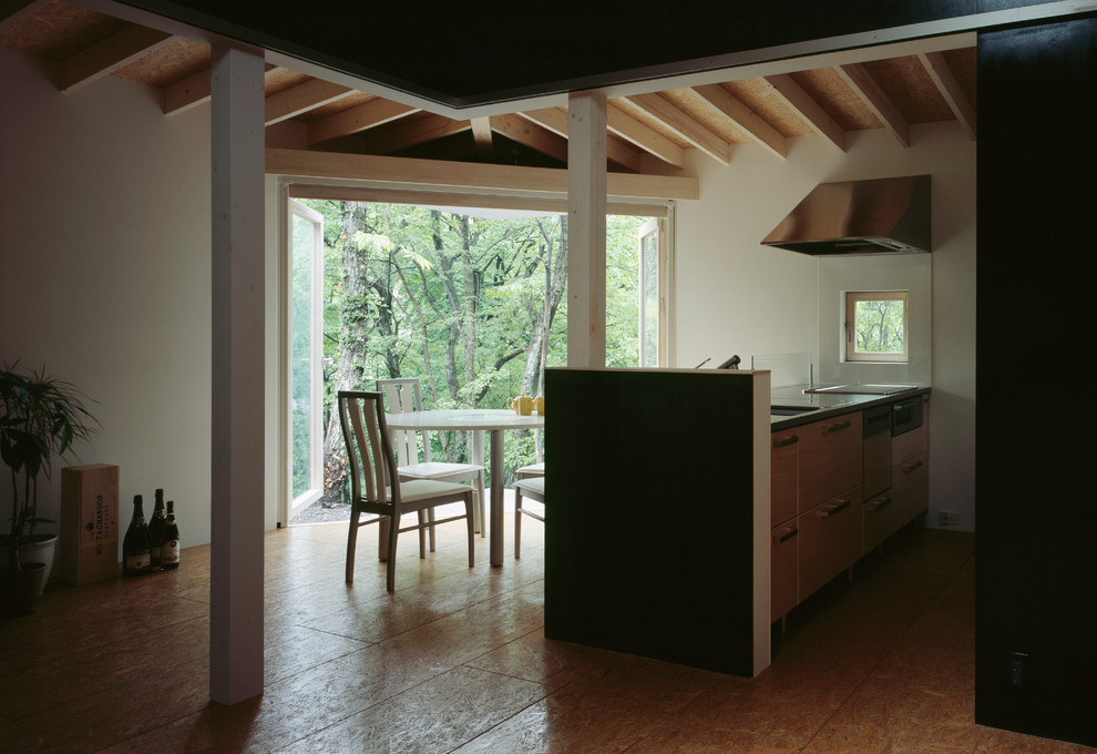 Idées déco pour une salle à manger ouverte sur la cuisine moderne avec un mur blanc et un sol marron.