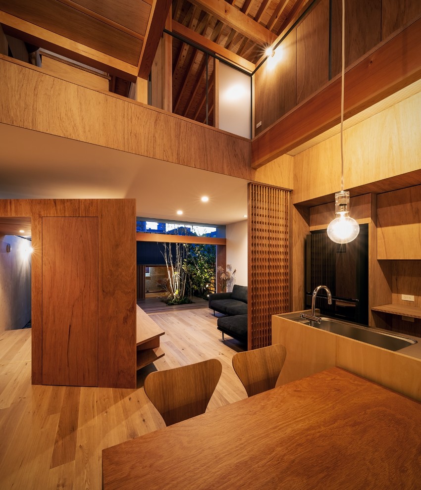 Foto di una sala da pranzo aperta verso il soggiorno etnica di medie dimensioni con pareti marroni, pavimento in legno massello medio e pavimento marrone