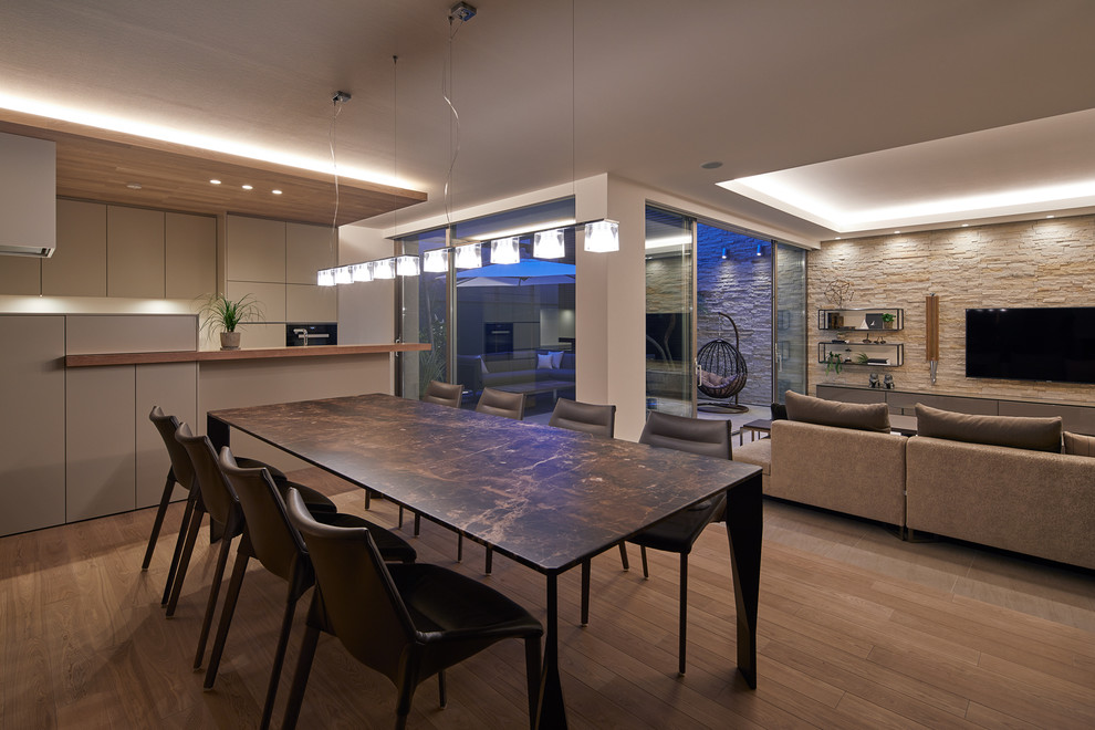 Идея дизайна: гостиная-столовая в стиле модернизм с белыми стенами, деревянным полом и коричневым полом