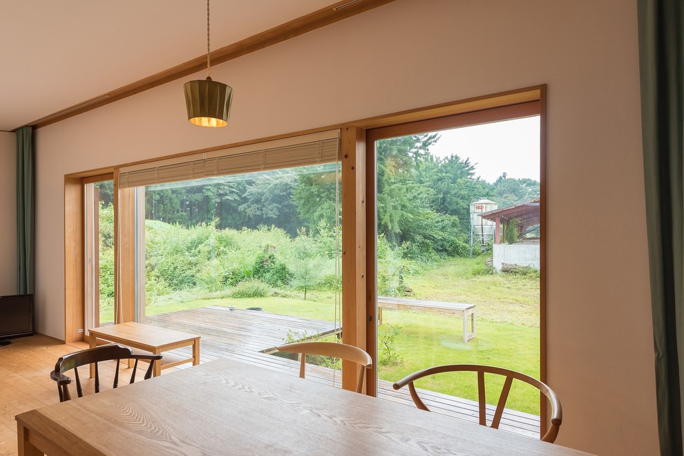 Esempio di una piccola sala da pranzo aperta verso il soggiorno nordica con pareti bianche, parquet chiaro, stufa a legna e pavimento beige