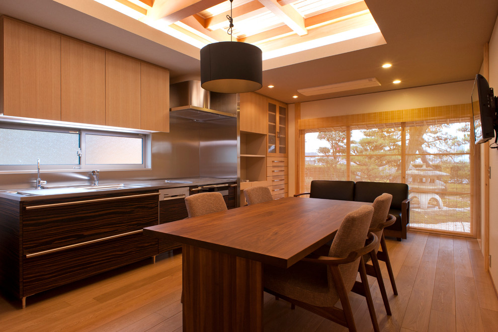 Ejemplo de comedor asiático abierto con paredes beige y suelo de madera en tonos medios