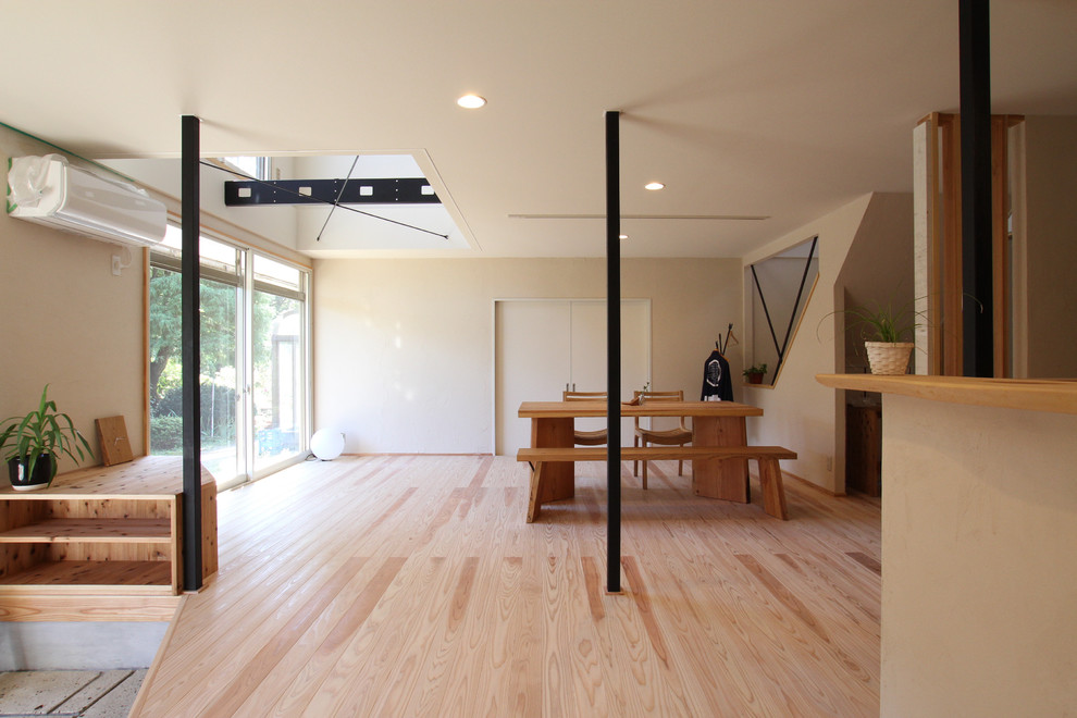 Asiatisches Esszimmer mit weißer Wandfarbe, hellem Holzboden und braunem Boden in Sonstige