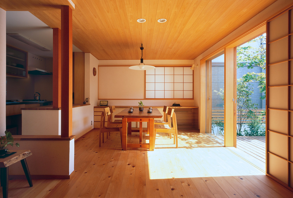 Immagine di una sala da pranzo etnica con pareti bianche, pavimento in legno massello medio e pavimento marrone