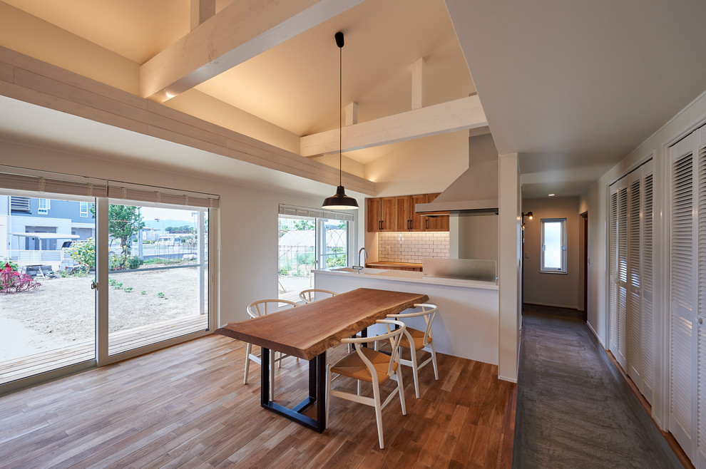 Diseño de comedor de estilo zen abierto con paredes blancas y suelo de madera en tonos medios