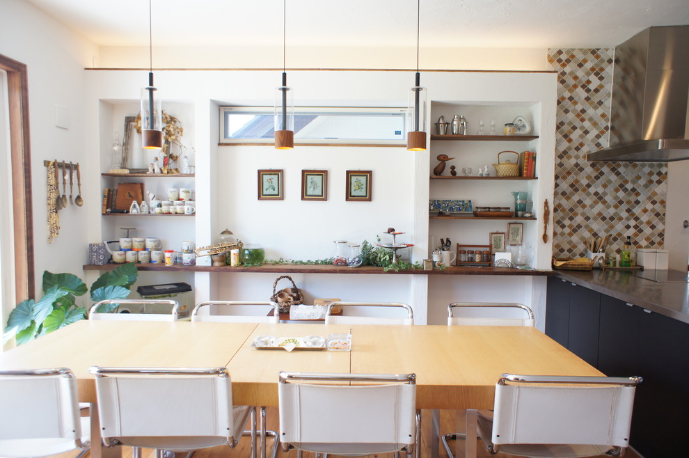 Cette image montre une salle à manger nordique avec un mur blanc et un sol en bois brun.