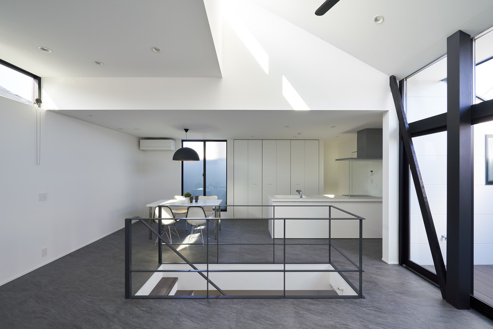 Photo of a modern open plan dining room in Tokyo with grey floors and white walls.