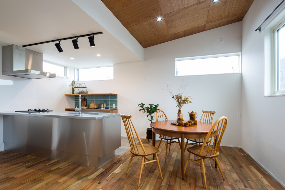Aménagement d'une salle à manger scandinave avec un sol en bois brun, un sol marron, un plafond en bois et du papier peint.