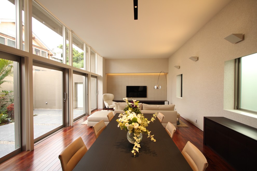 Esempio di una sala da pranzo contemporanea con pareti bianche, pavimento in legno verniciato e pavimento marrone