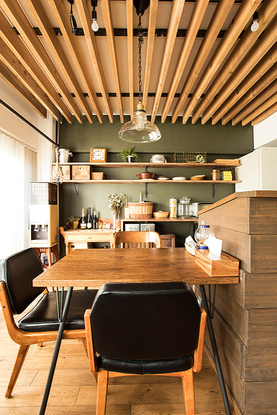 Immagine di una sala da pranzo aperta verso il soggiorno rustica di medie dimensioni con pareti grigie, pavimento in legno massello medio, nessun camino e pavimento marrone