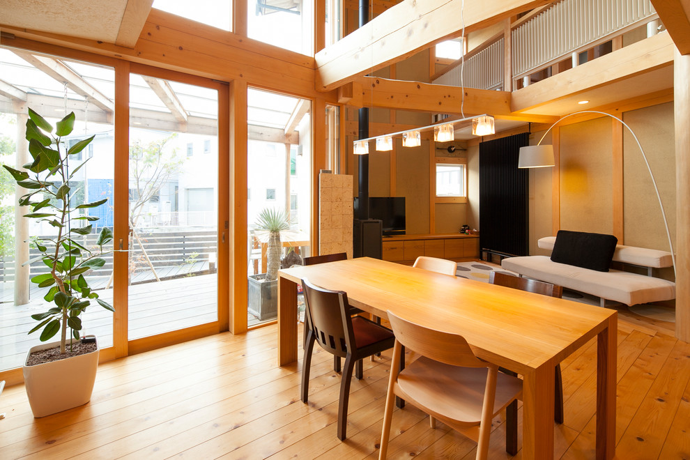 Exemple d'une salle à manger ouverte sur le salon tendance avec un mur marron, un sol en bois brun et un sol marron.