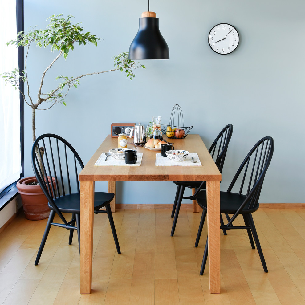 Esempio di una sala da pranzo minimal con pareti blu, pavimento in legno massello medio e pavimento marrone
